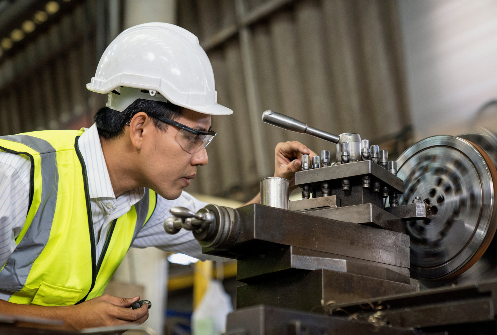 Hombre supervisando torno